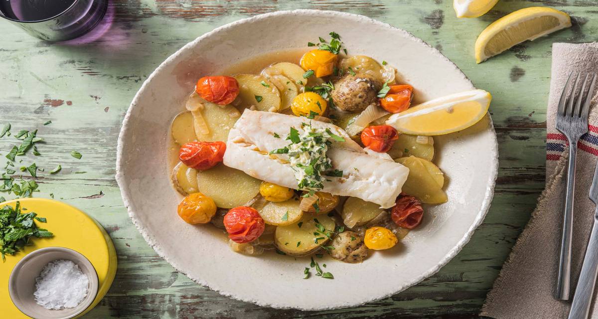 Cabillaud à la méditerranéenne et pommes de terre à l’étuvée servis avec un beurre aux fines herbes maison et des tomates cerises du four