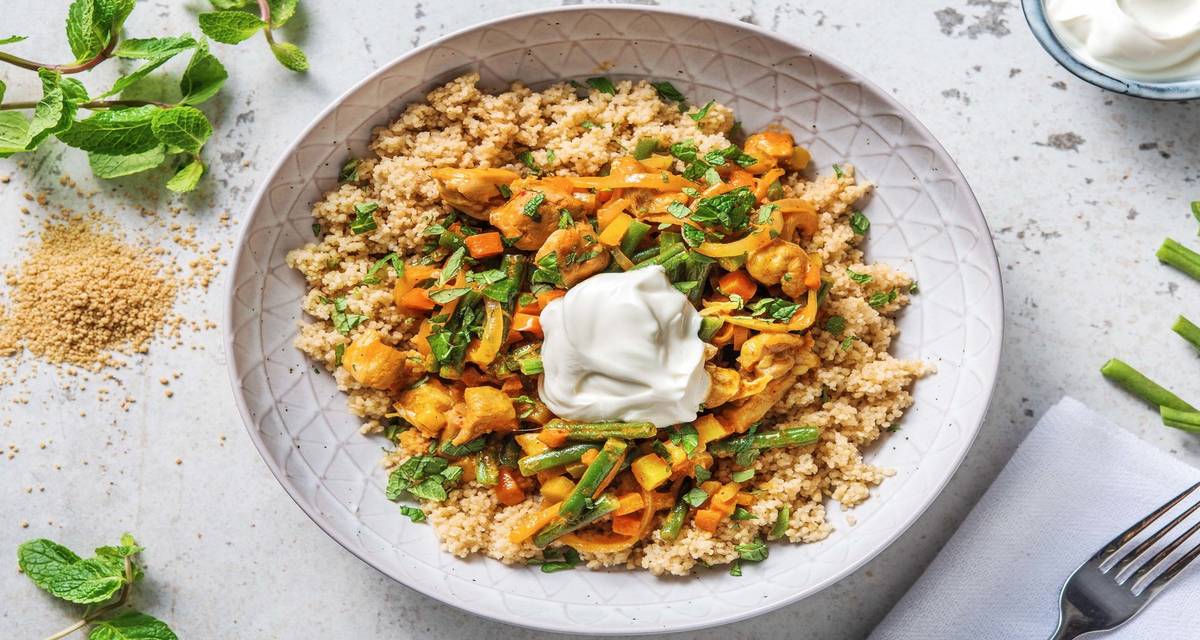 Curry au poulet et aux haricots verts servi avec de la semoule complète, de la menthe et du yaourt