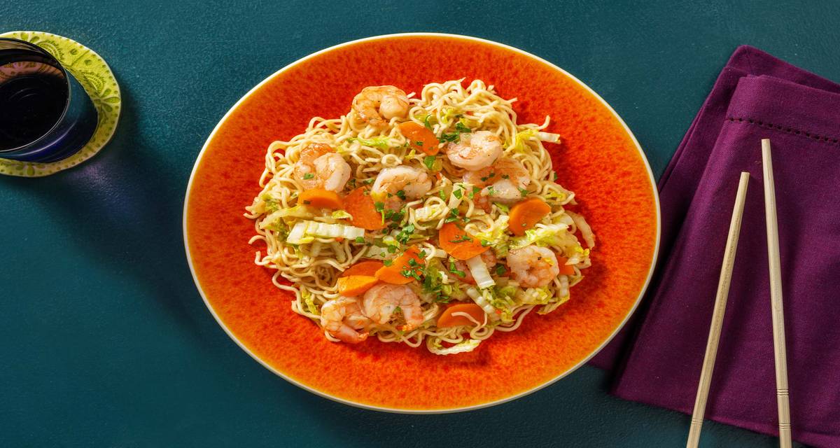 Nouilles sautées aux crevettes et chou chinois préparées avec de la carotte, du gingembre et de la coriandre