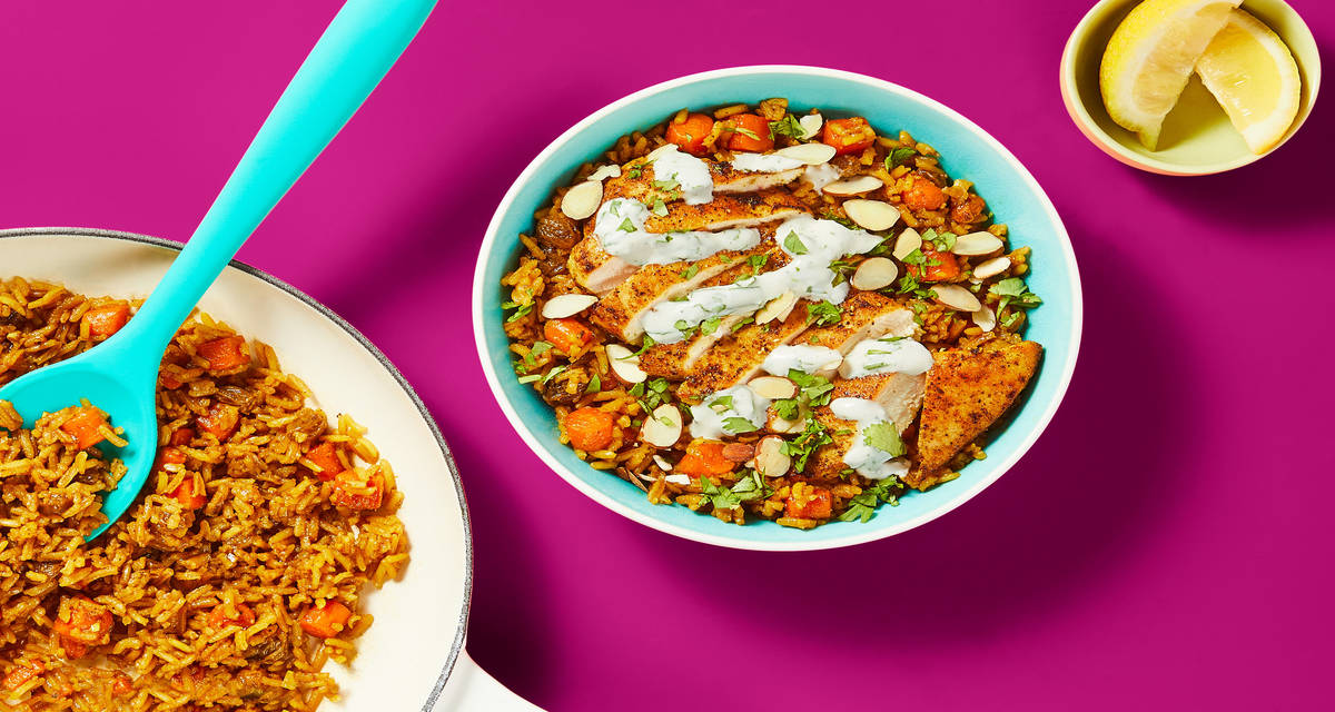 One-Pan Shawarma-Spiced Chicken & Rice with Golden Raisins, Carrots & Cilantro Crema