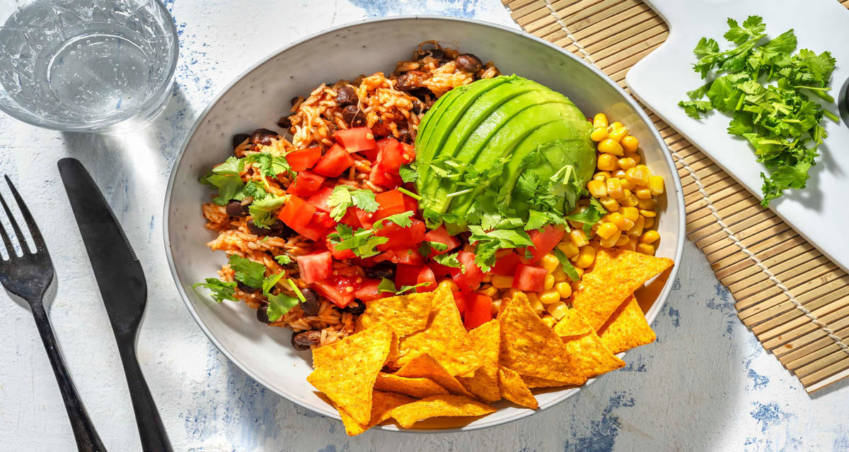 Riz à la mexicaine et chips de tortillas préparés avec de la tomate, des haricots noirs, du maïs et de l’avocat