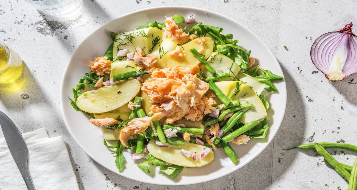 Salade de grenailles tiède aux miettes de saumon et haricots verts servie avec des rubans de courgette blanche