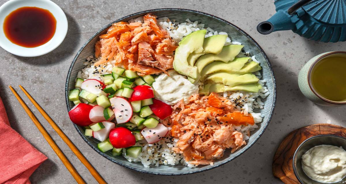 Sushi bowl au saumon fumé et mayonnaise au gingembre servi avec des radis et du concombre à l'aigre-douce