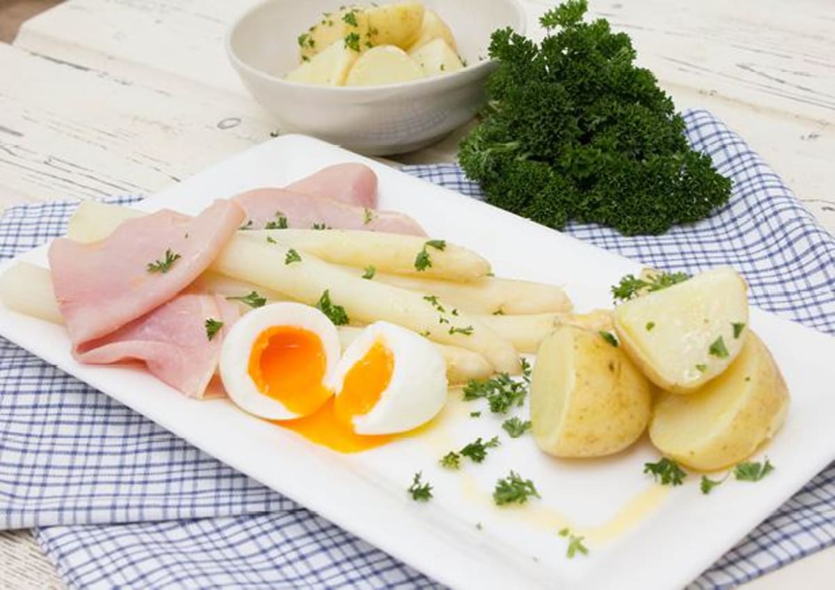 Witte asperges met boerenachterham en een zacht gekookt ei