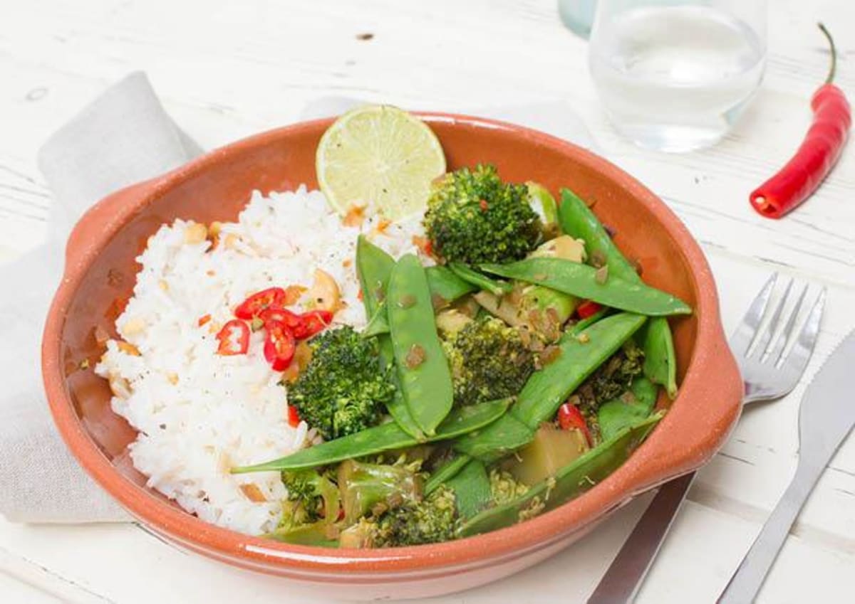 Oosterse wok met groene groenten, notenrijst en frisse limoen