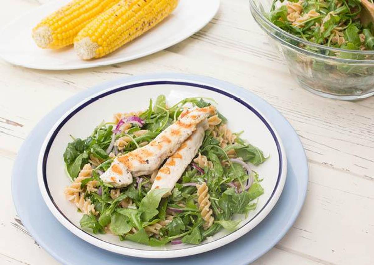 Zomerse pasta met rucola, kipfilet, Parmezaandressing en een maïskolf