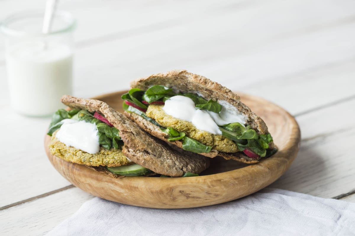 Volkoren pitabrood met falafelburgers, frisse salade en romige yoghurtsaus