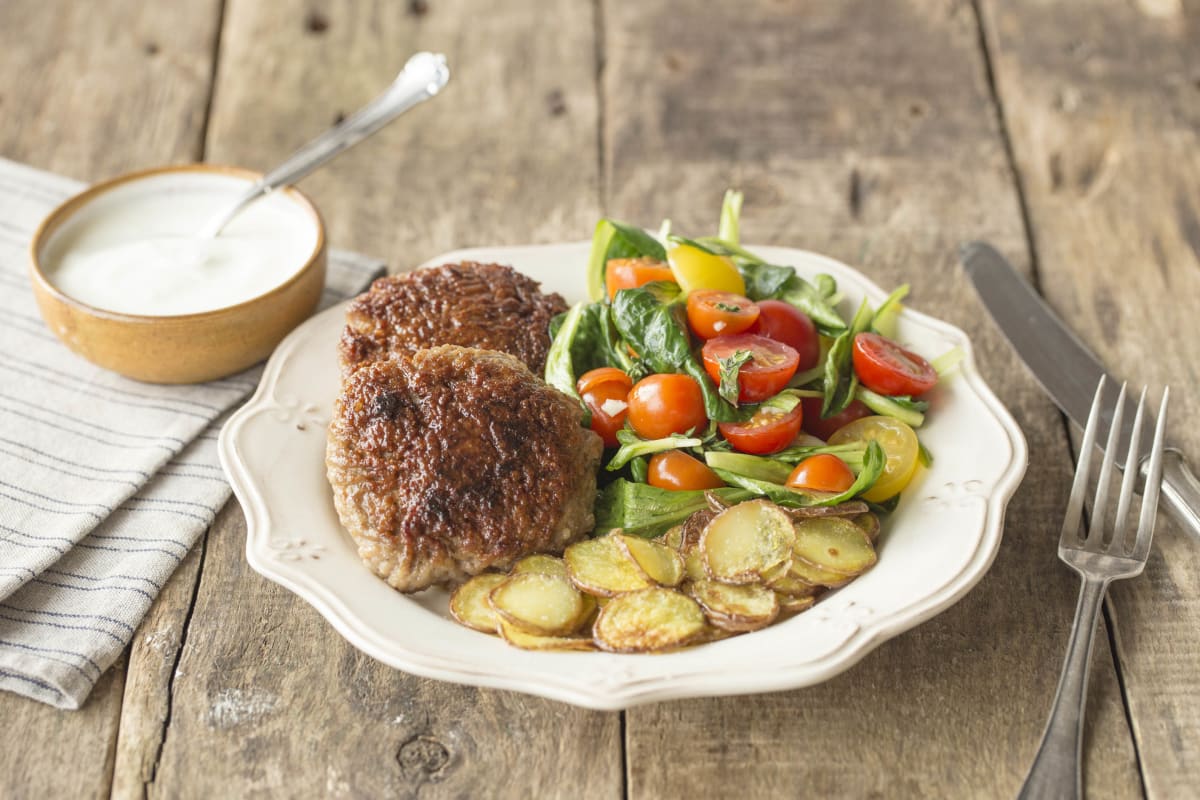 Hamburgertjes met gebakken rosevalaardappelen en tomatensalade