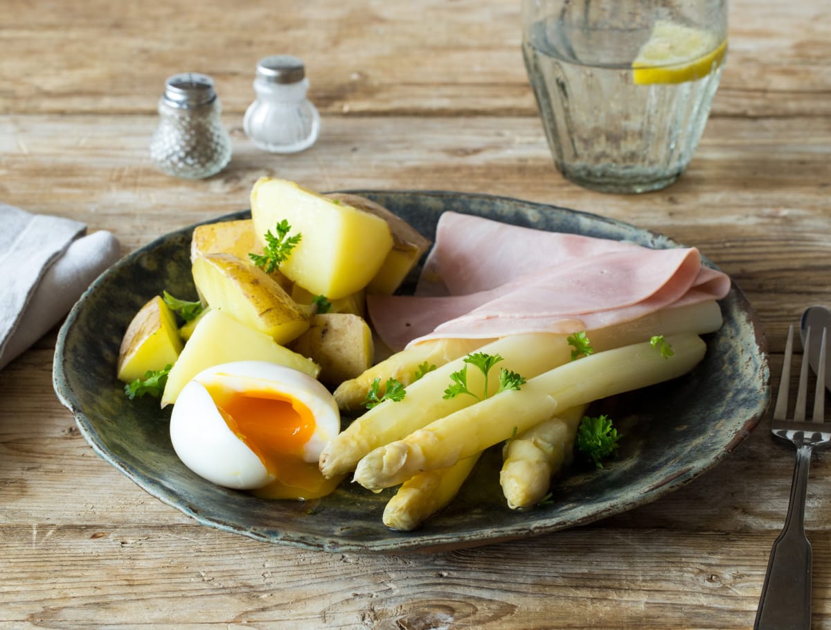 Witte asperges met boerenachterham, gekookt ei en peterselie
