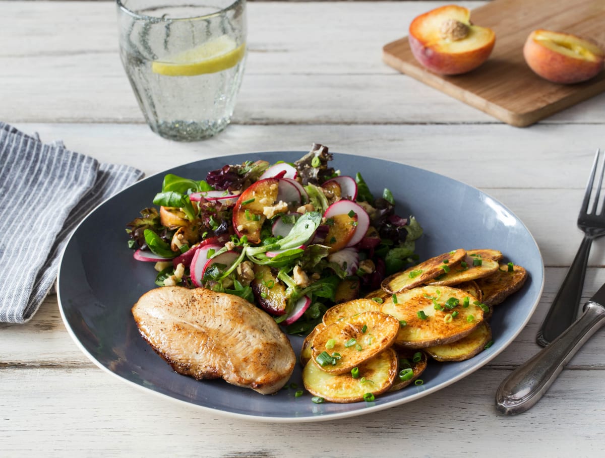 Gebakken kipfilet, ovenaardappelen en salade met gegrilde perzik