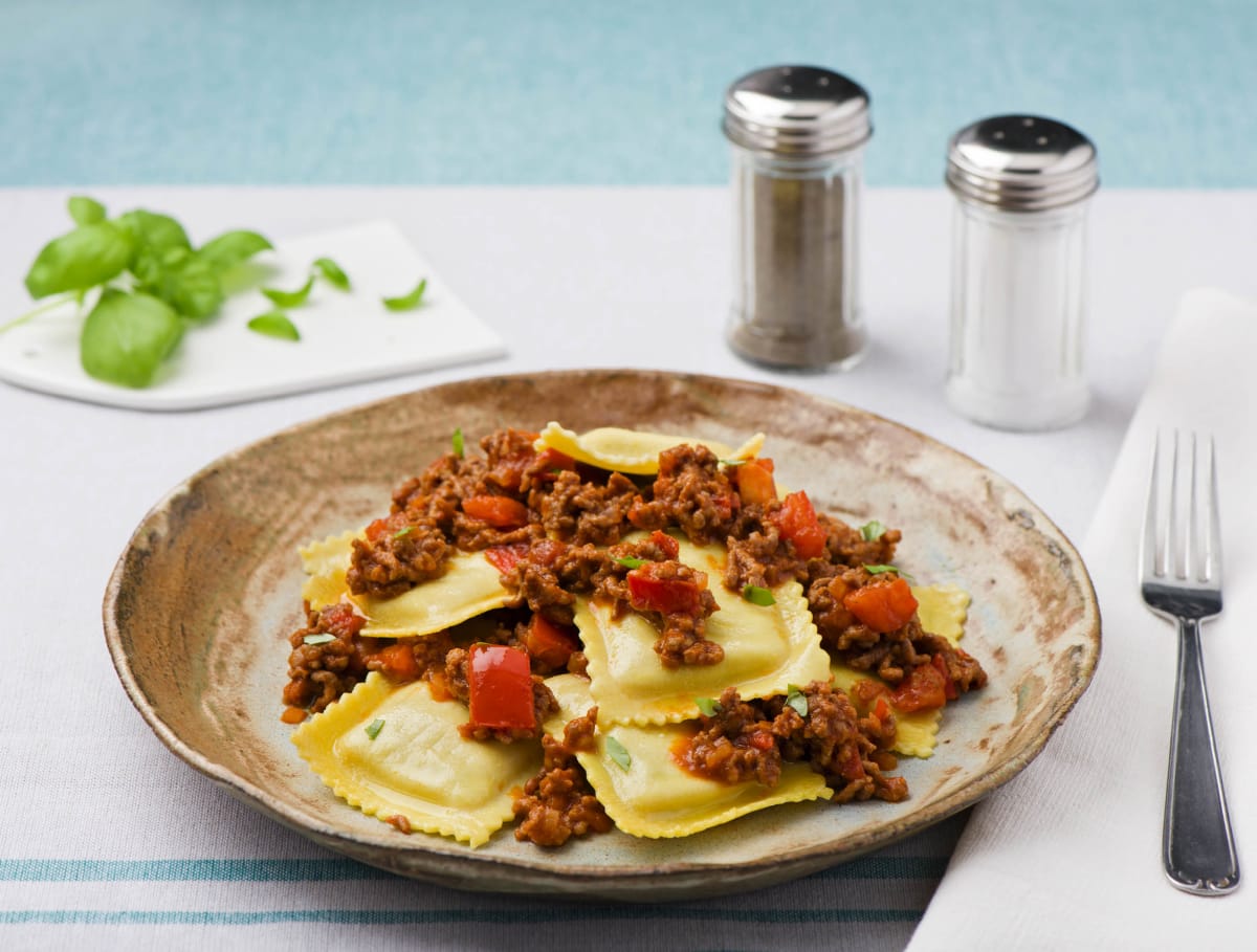Verse ravioli gevuld met spinazie en ricotta met gehakt-tomatensaus