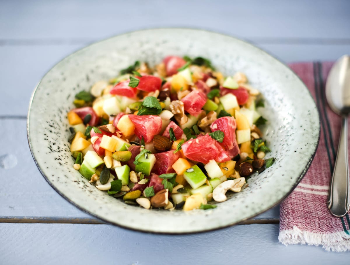 Fruitsalade met een notenmix en verse munt