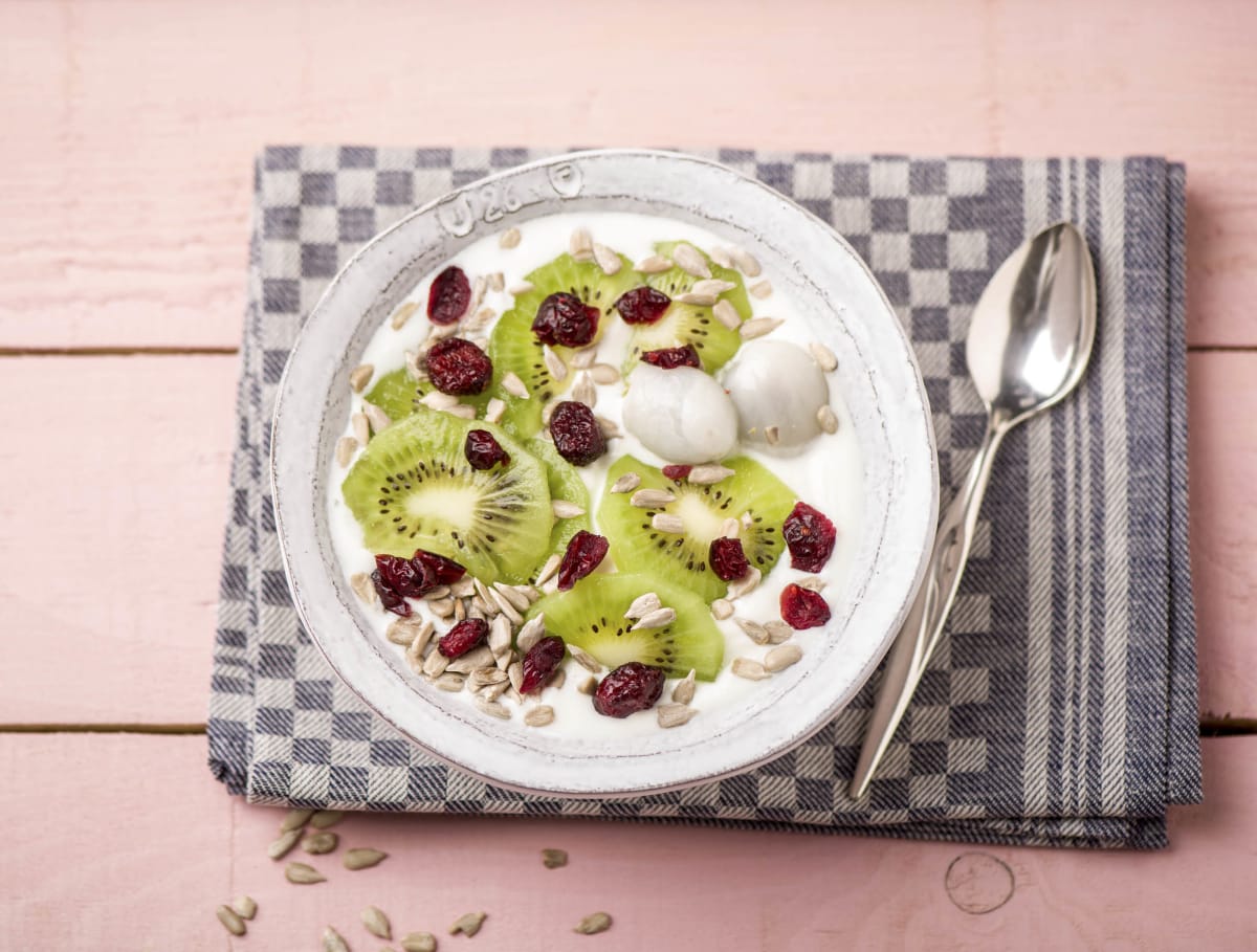 Halfvolle yoghurt met lychees, kiwi en cranberry-pittenmix