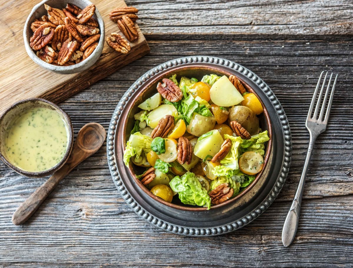 Zomerse krieltjessalade met gele tomaten, oude komijnekaas en sinaasappel-oreganodressing