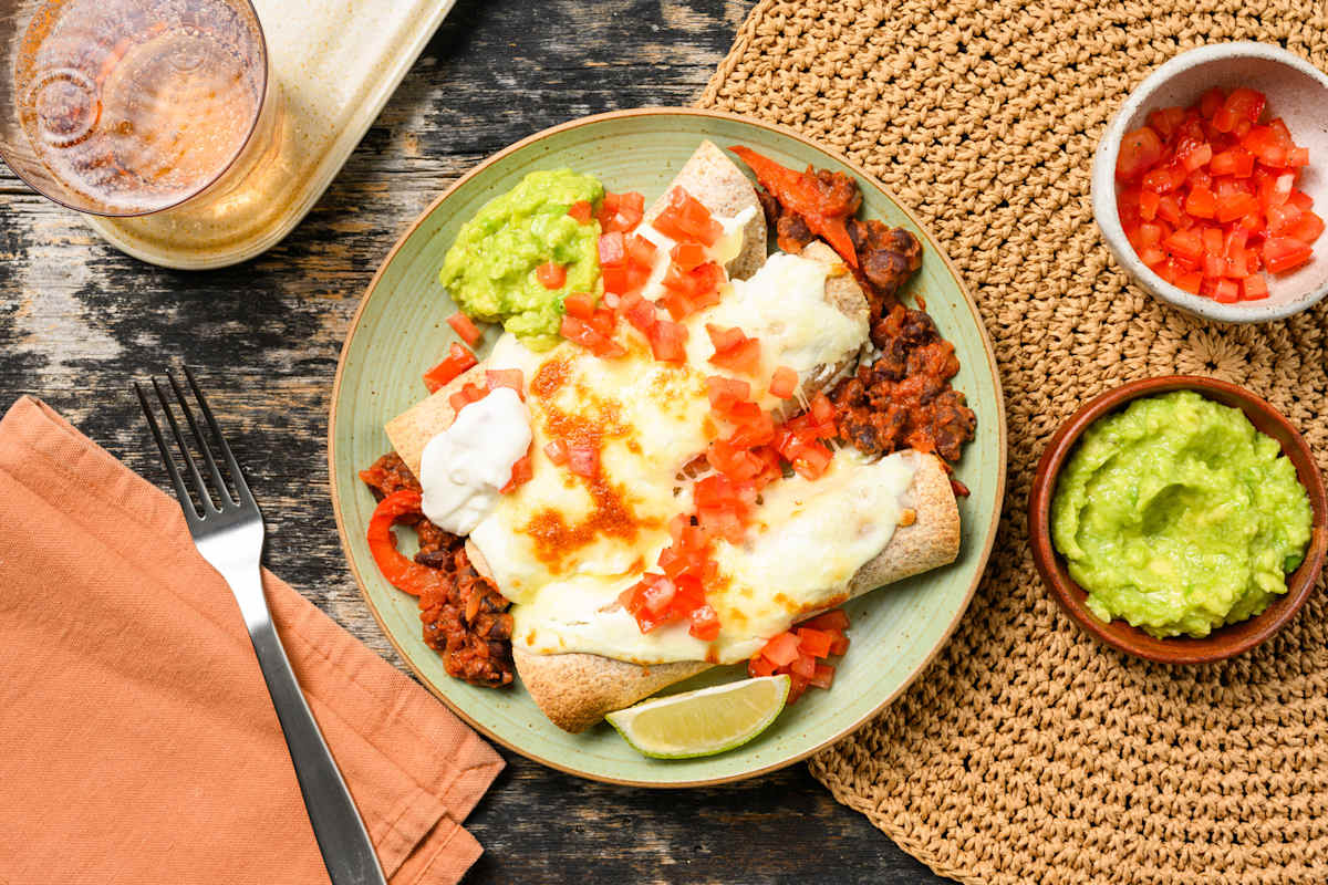 Cheesy pittige enchilada's gevuld met zwarte bonen en tomaat