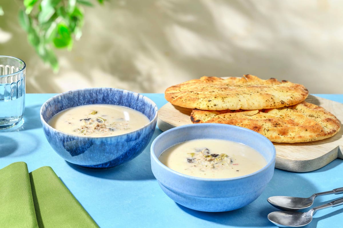 Verse Thaise kokos-kippensoep en naanbrood met kruiden