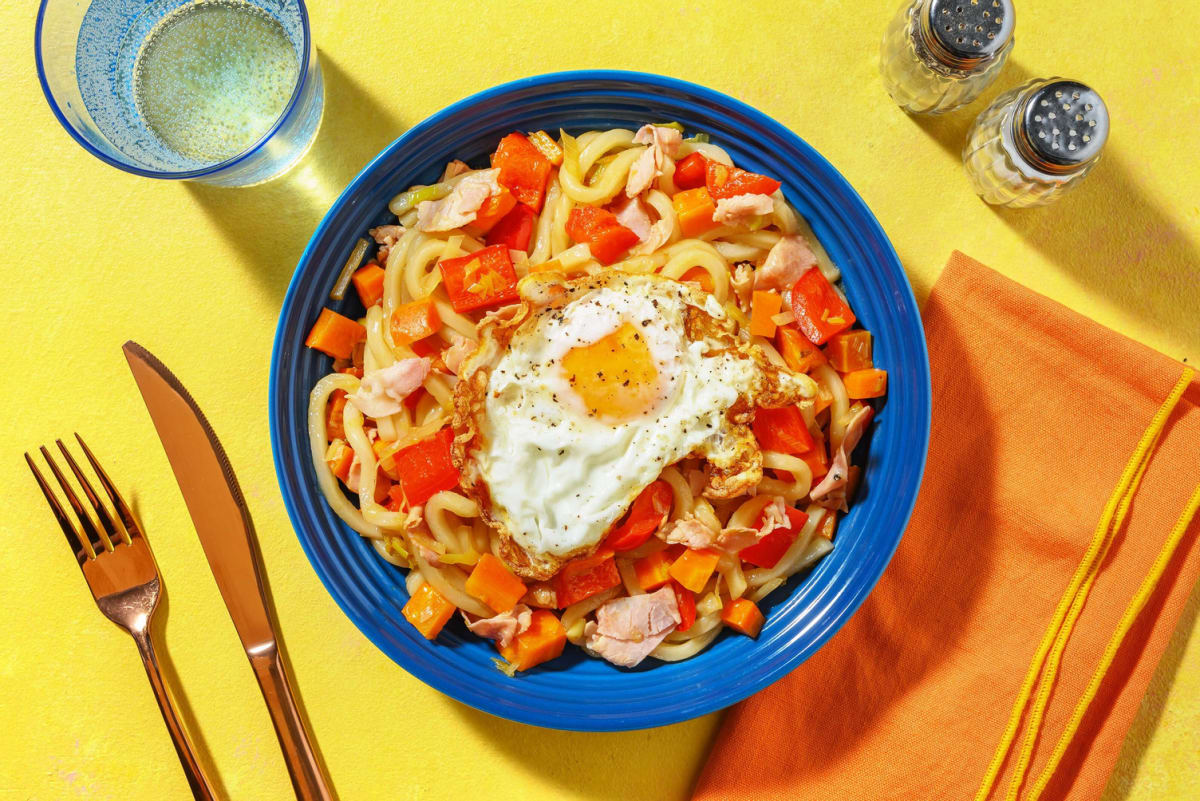 Nouilles udon sautées garnies de jambon et œuf au plat