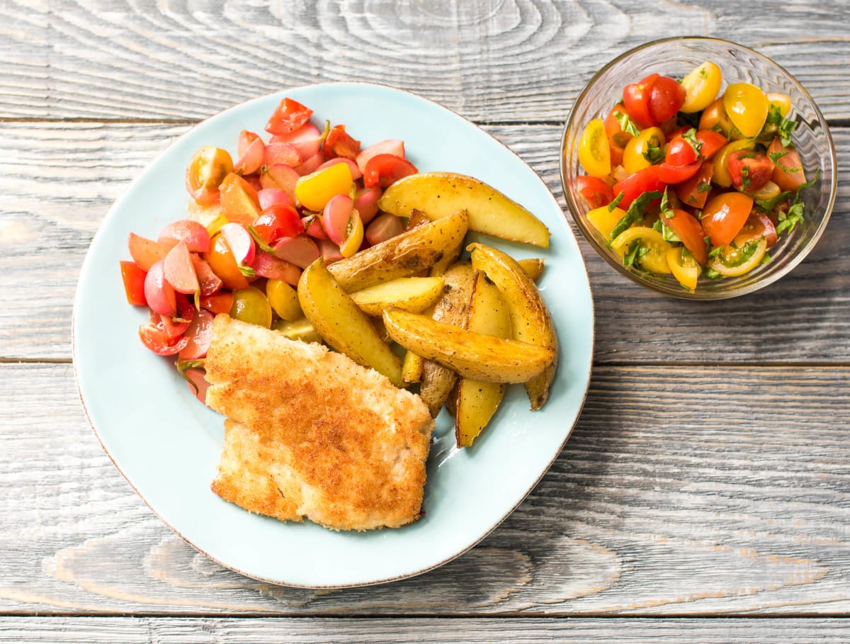 Visschnitzel met gesmoorde radijs, aardappelen en cherrytomaten