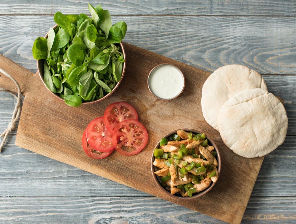 Volkoren pitabroodjes met kipfiletreepjes, yoghurt en salade