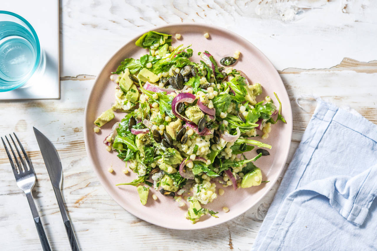 Ensalada de cuscús y queso griego con aguacate, semillas de calabaza y hierbas aromáticas