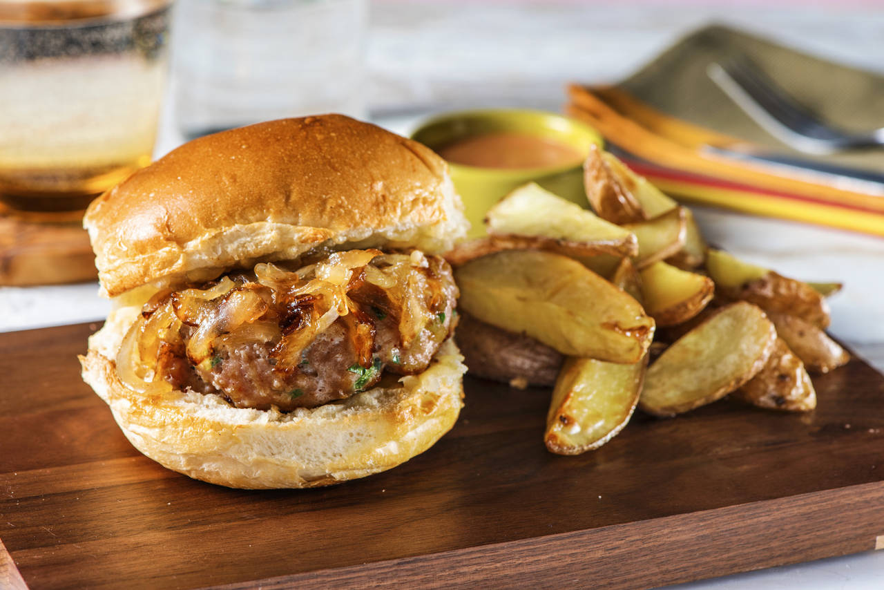 Hamburguesa casera de cerdo y perejil con cebolla caramelizada y patatas al horno