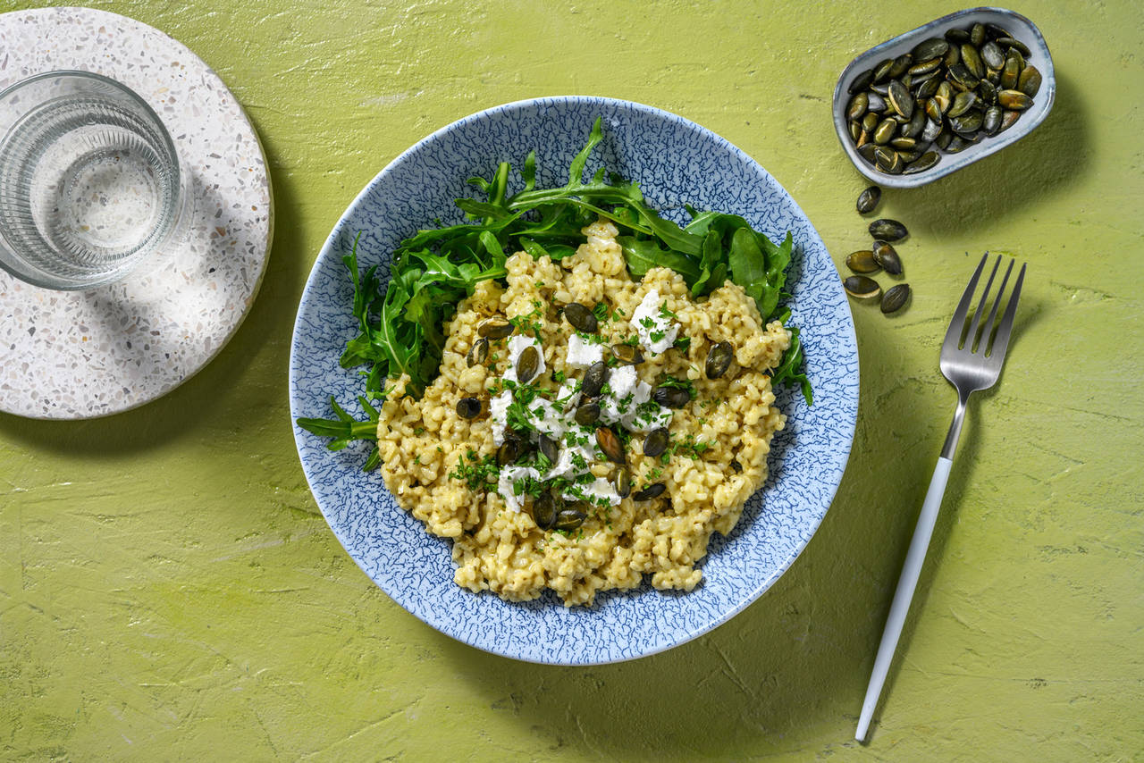Risotto de pesto de albahaca y queso griego con semillas de calabaza tostadas y perejil
