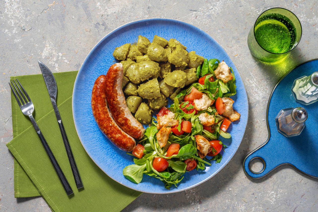 Salchichas de cerdo con patatas al pesto y ensalada con picatostes caseros