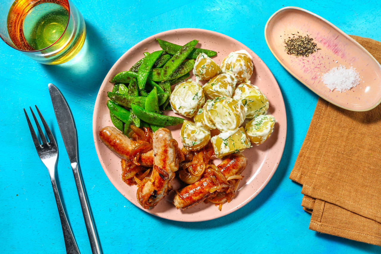 Salchichas encebolladas con patatas al eneldo y tirabeques salteados