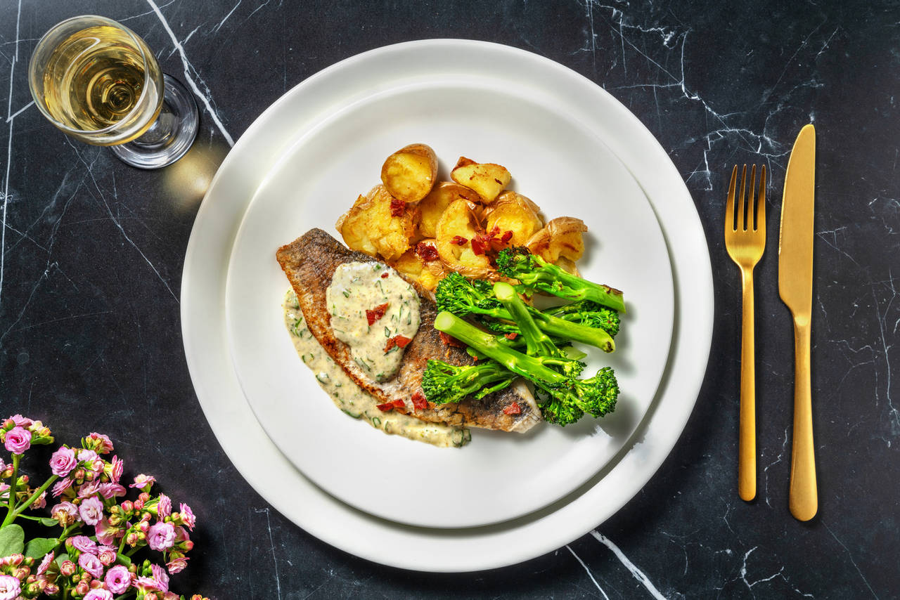 Dorada con salsa cremosa de estragón y bacon acompañada de patatas crujientes y brocolini asado