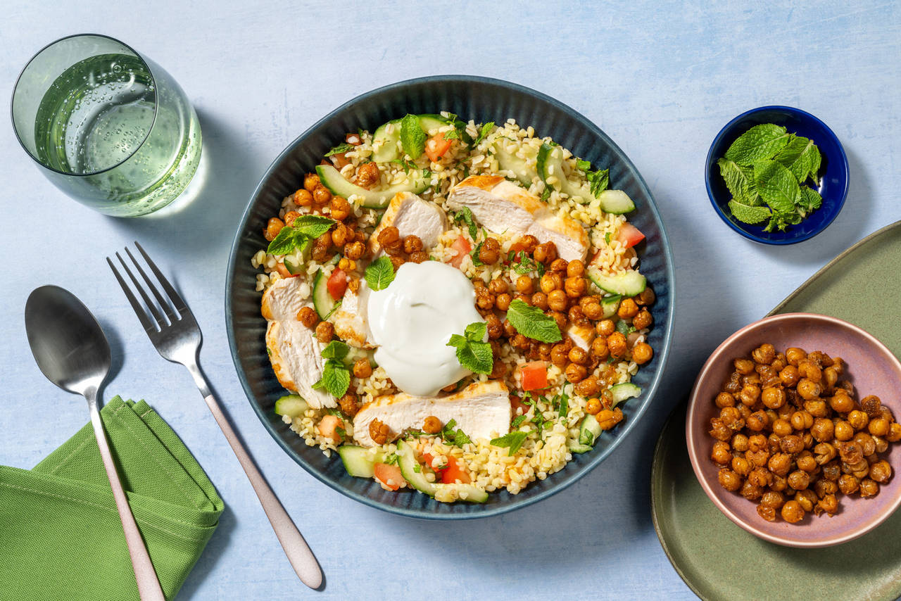 Bol griego de pollo y garbanzos asados con salsa de yogur sobre bulgur con verduras