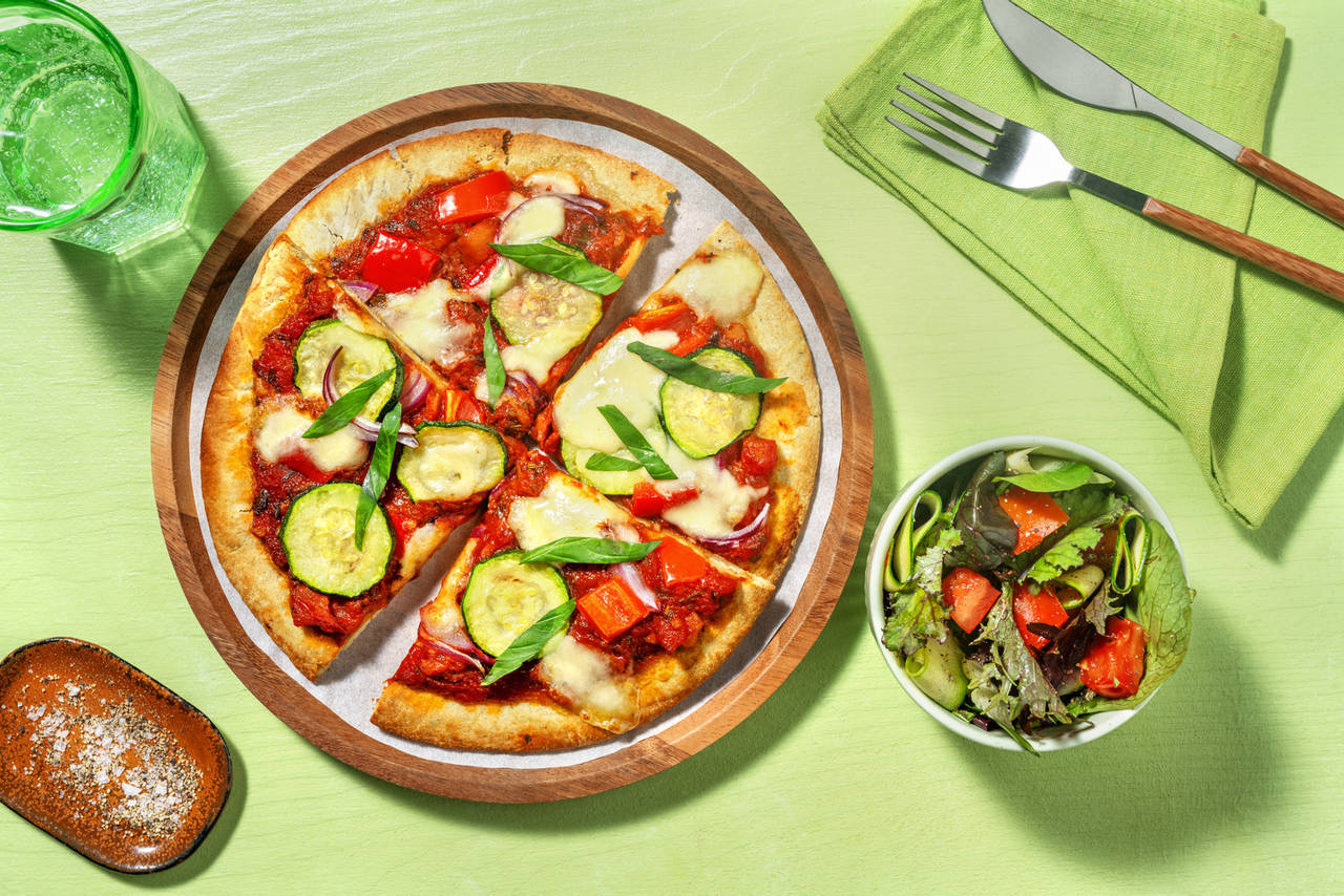 Pizza de calabacín y mozzarella acompañada de ensalada fresca