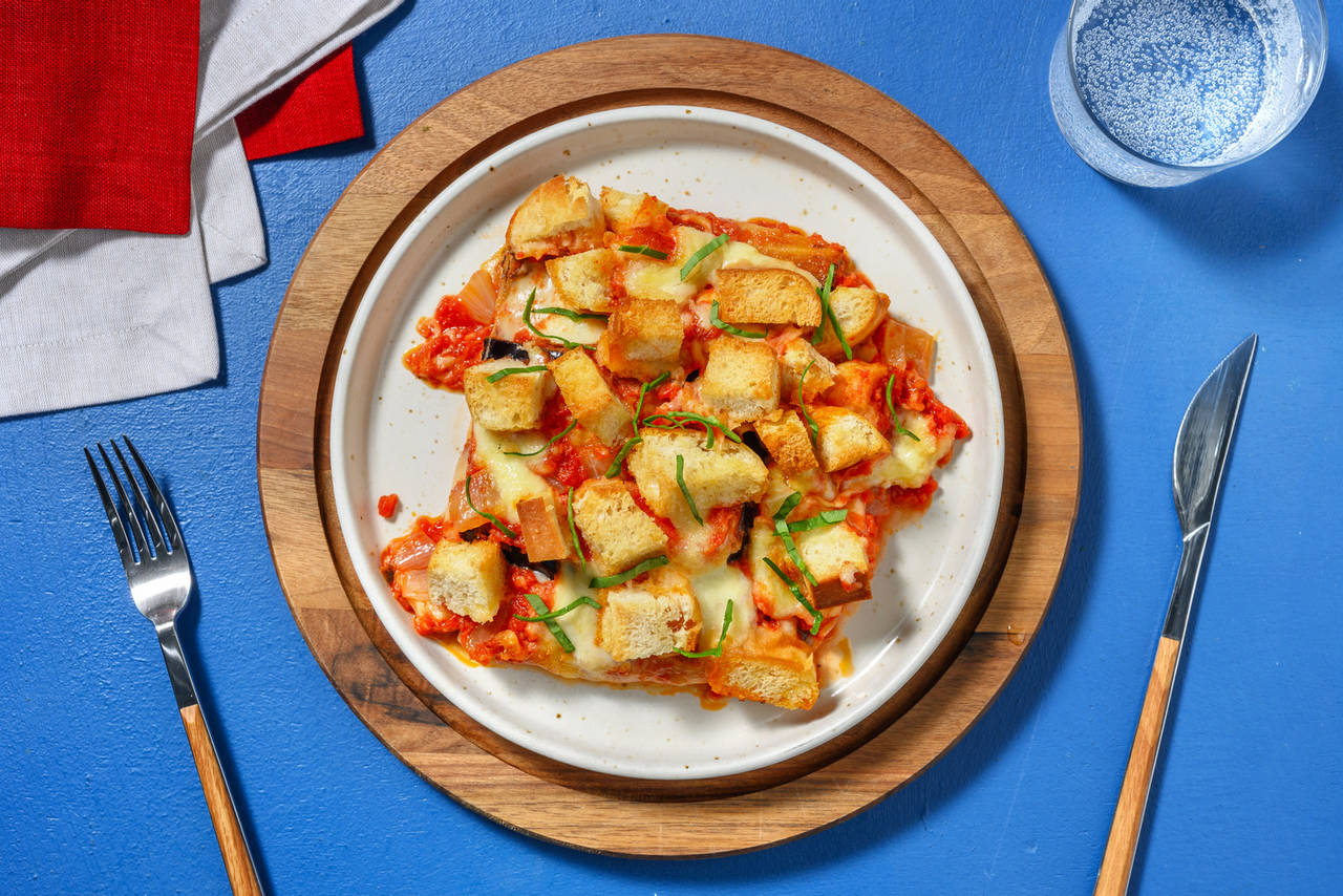 La parmigiana: berenjena con mozzarella italiana con salsa de tomate y picatostes caseros