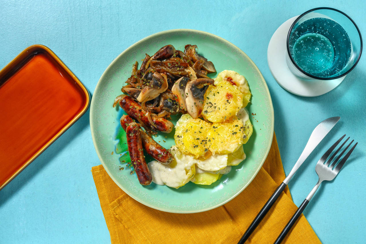 Salchichas con patatas al gratén con cebolla y setas portobello salteadas