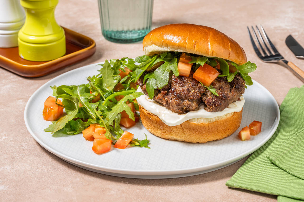 Hamburguesa casera de ternera con mayonesa acompañada de ensalada de rúcula y tomate