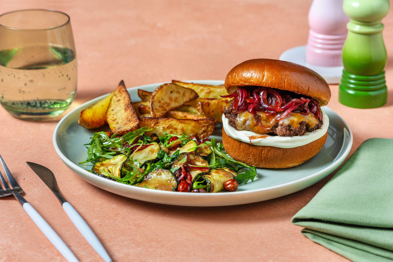 Hamburguesa con queso y cebolla caramelizada con patatas al horno y ensalada de calabacín y avellanas