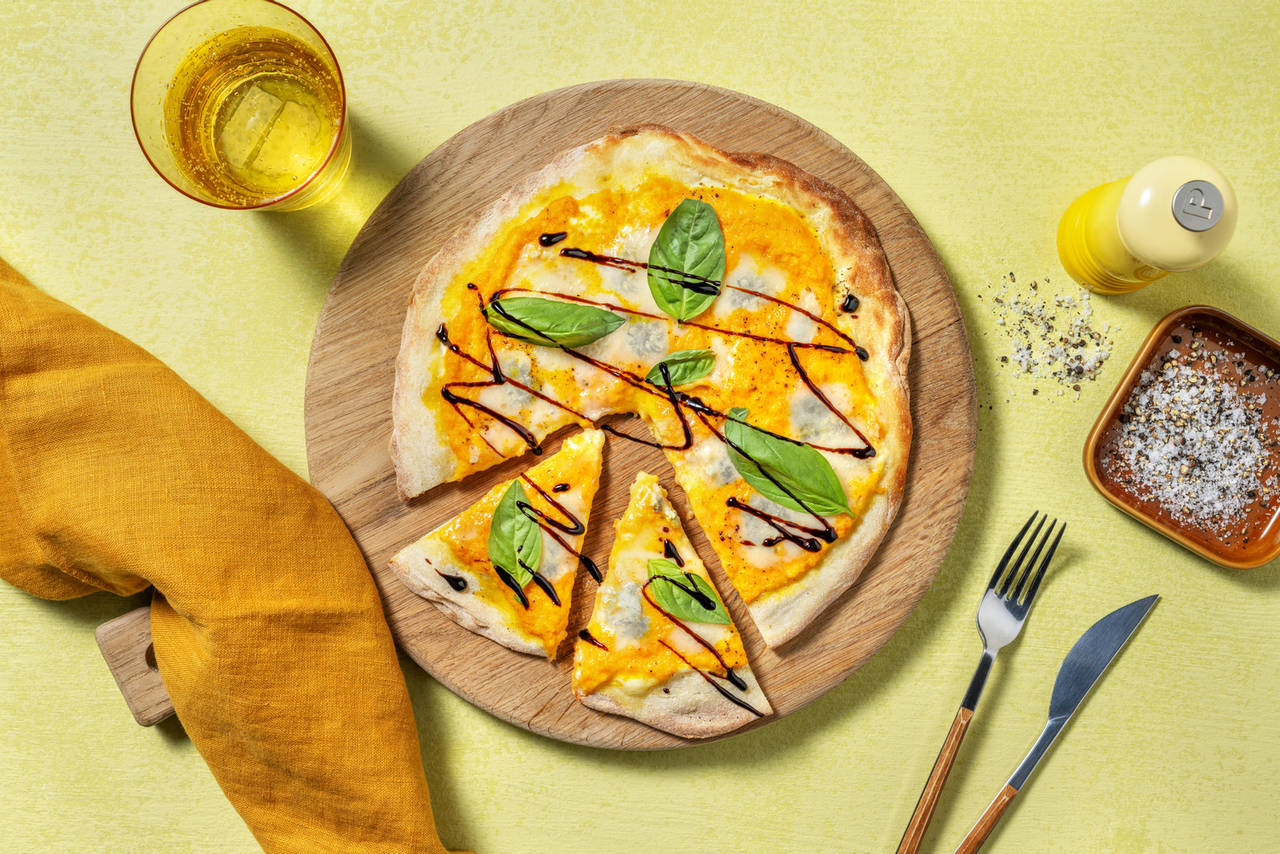 Pizza de crema de zanahoria y queso azul con albahaca fresca y crema de vinagre balsámico