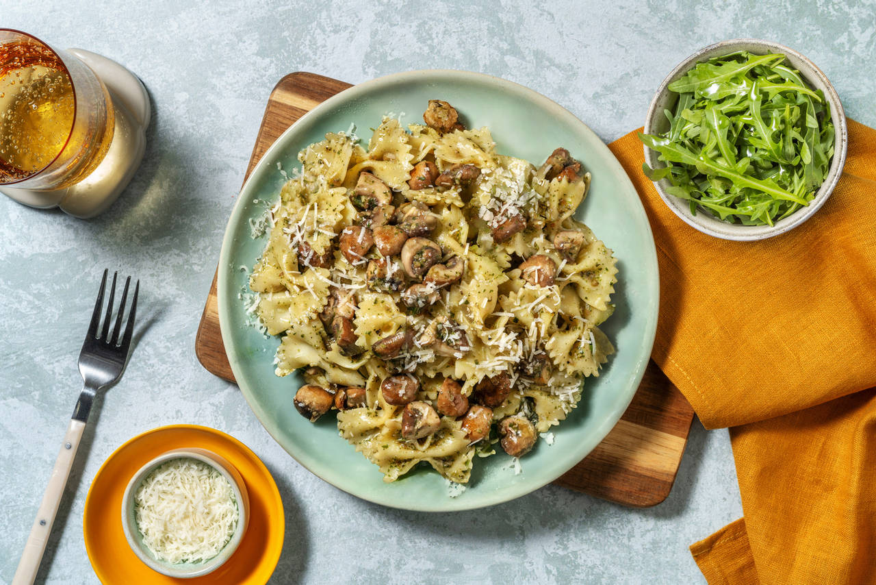 Farfalle con pesto y portobellos con queso italiano y ensalada de rúcula