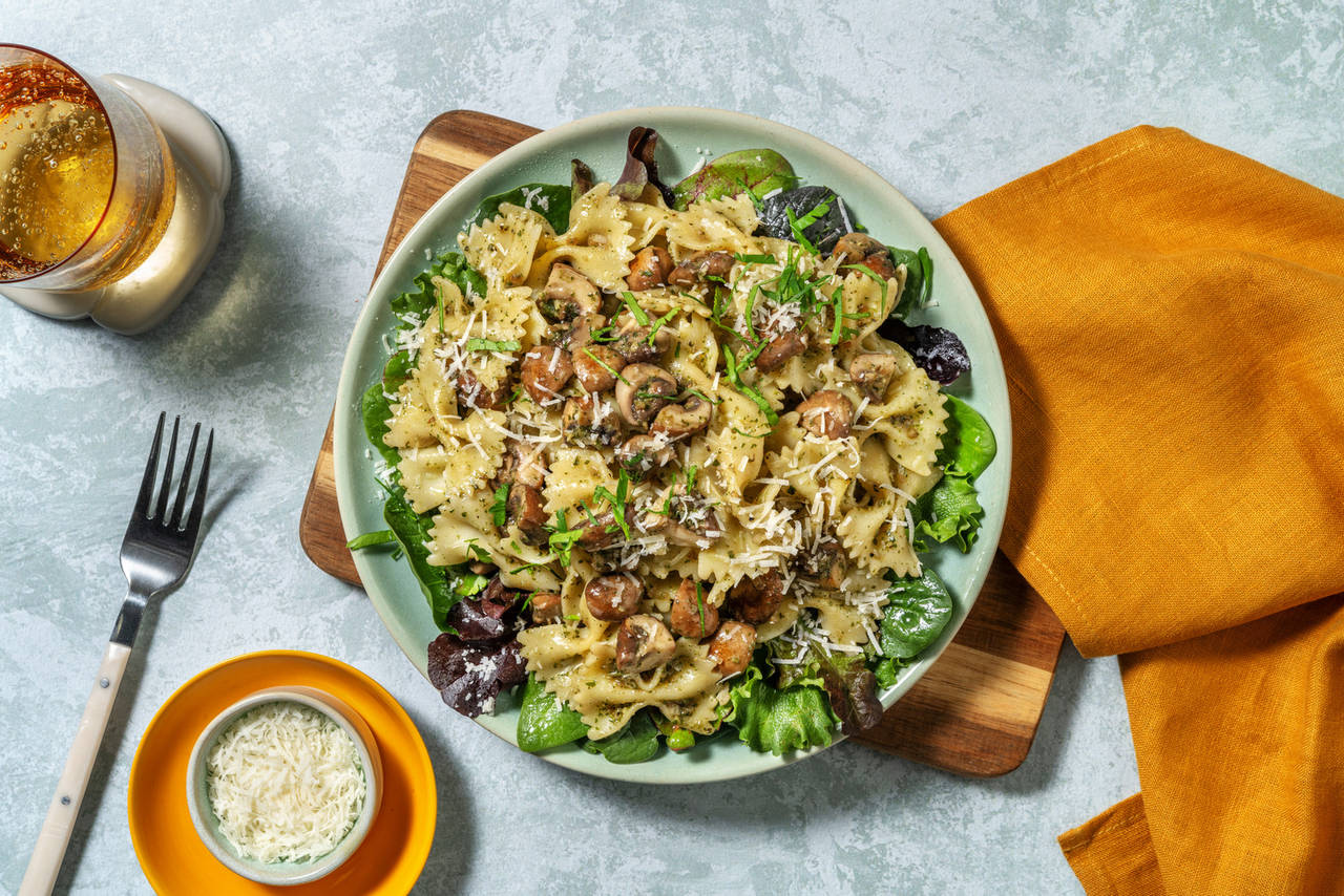 Farfalle con pesto y portobellos sobre una base de ensalada fresca