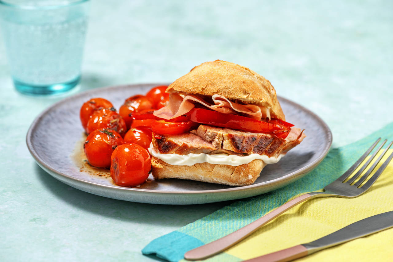 Bocadillo de lomo con jamón serrano acompañado de pimientos fritos y cherrys salteados