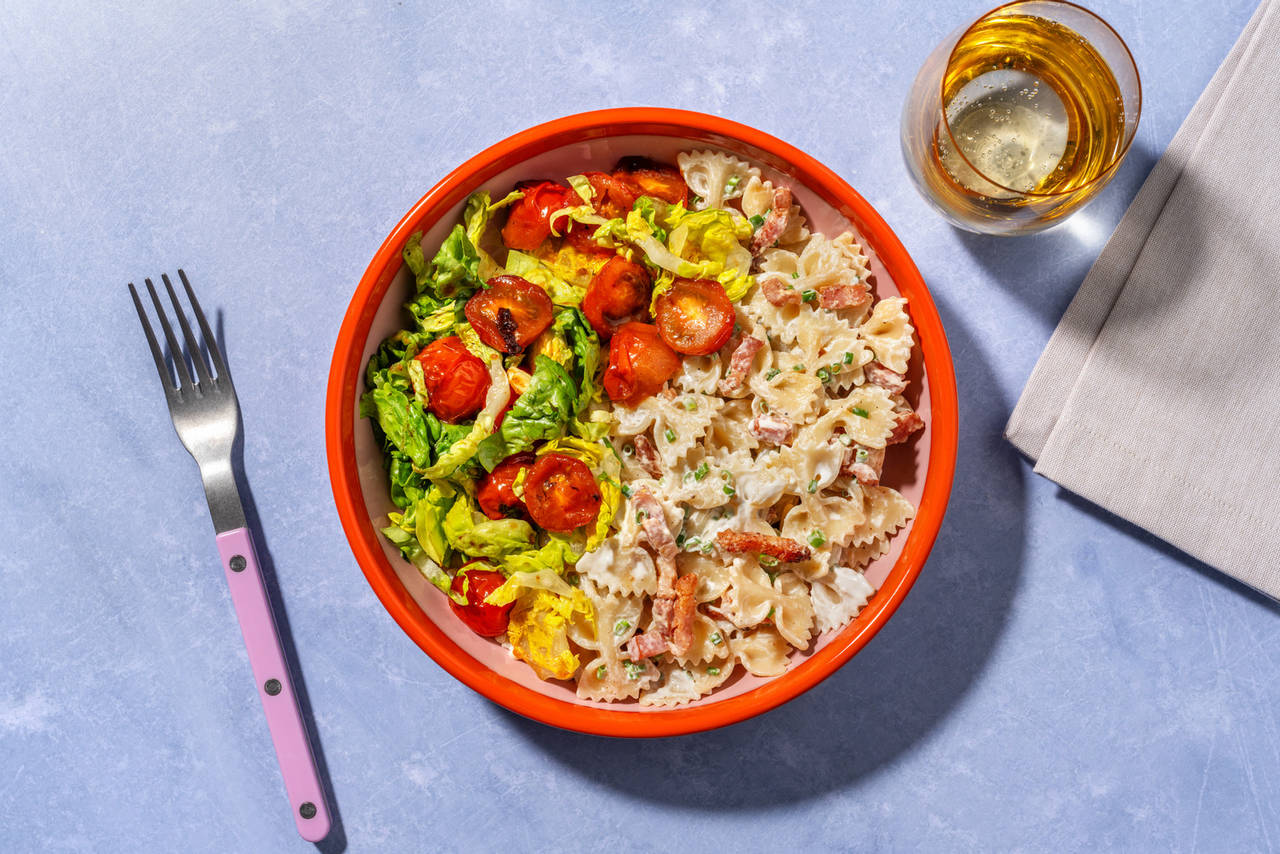 Farfalle con bacon en salsa de cebollino con ensalada de tomates cherry salteados