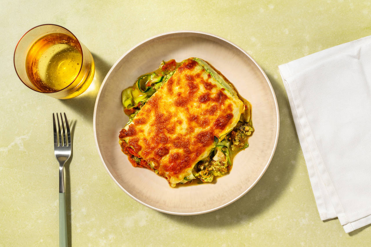 Lasaña bicolor de tofu en salsa de espinacas con salsa de tomate, verduras y queso gratinado