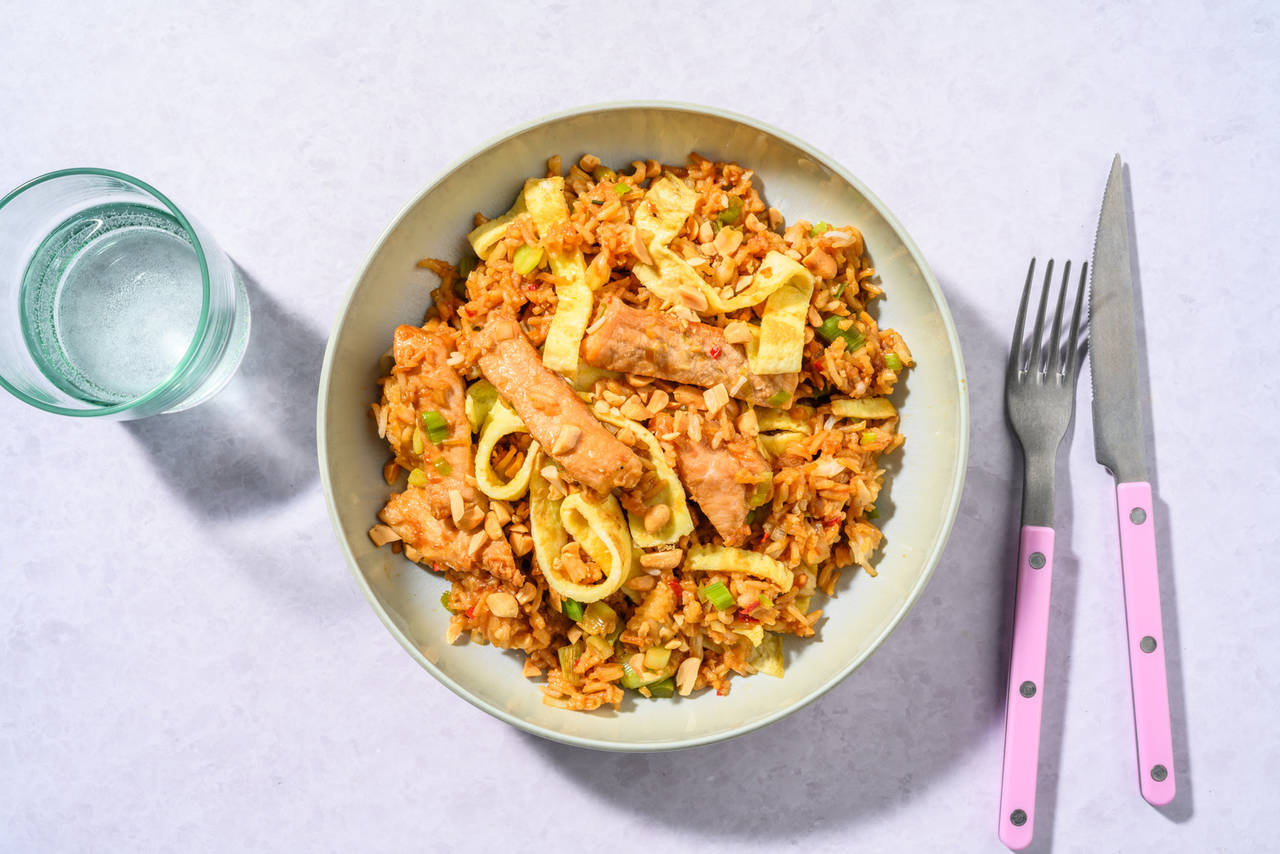 Arroz frito con cerdo marinado con tortilla, anacardos picados y chili rojo