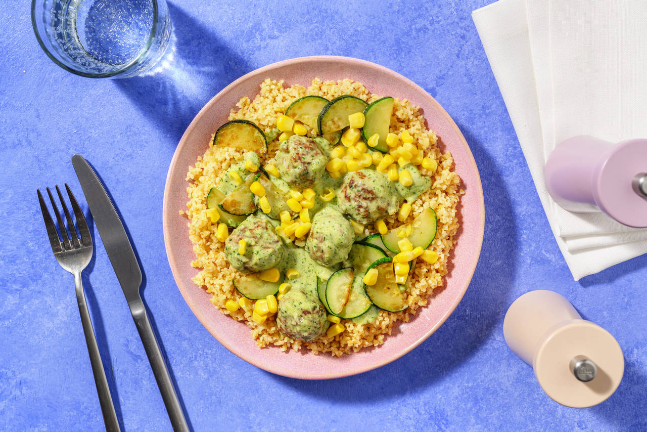 Albóndigas con salsa de calabacín y cilantro sobre bulgur con maíz dulce