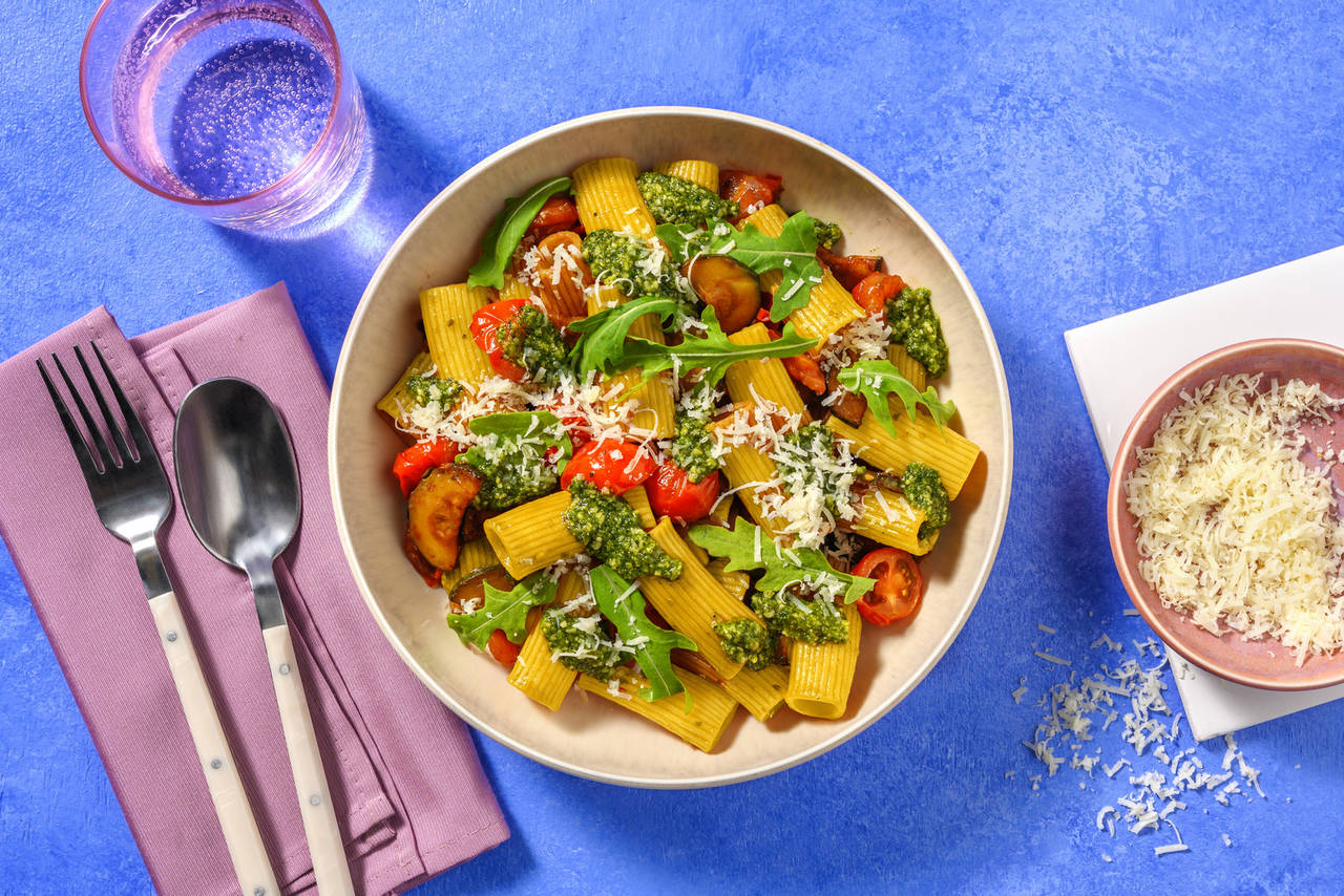 Rigatoni al pesto casero de rúcula con verduras y queso italiano rallado