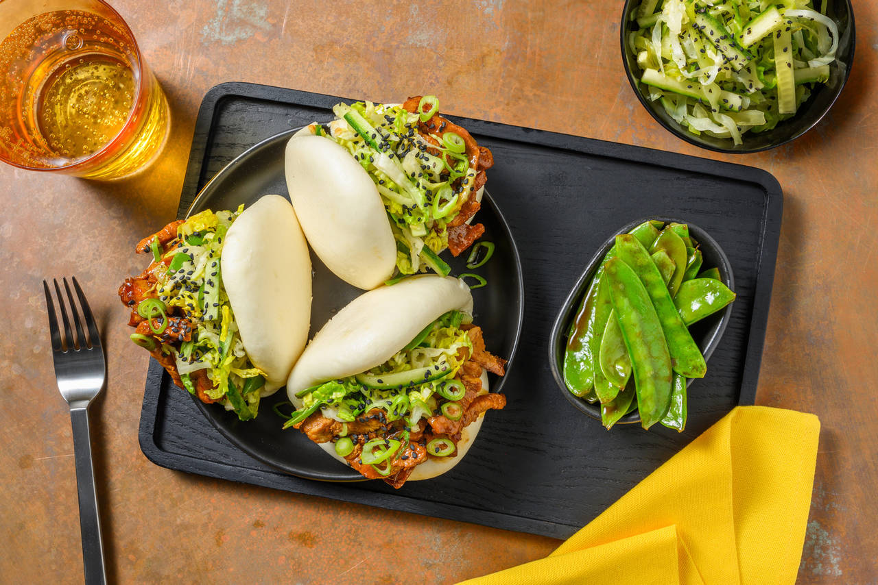 Baos de cerdo en salsa asiática dulce con ensalada de pepino y tirabeques salteados