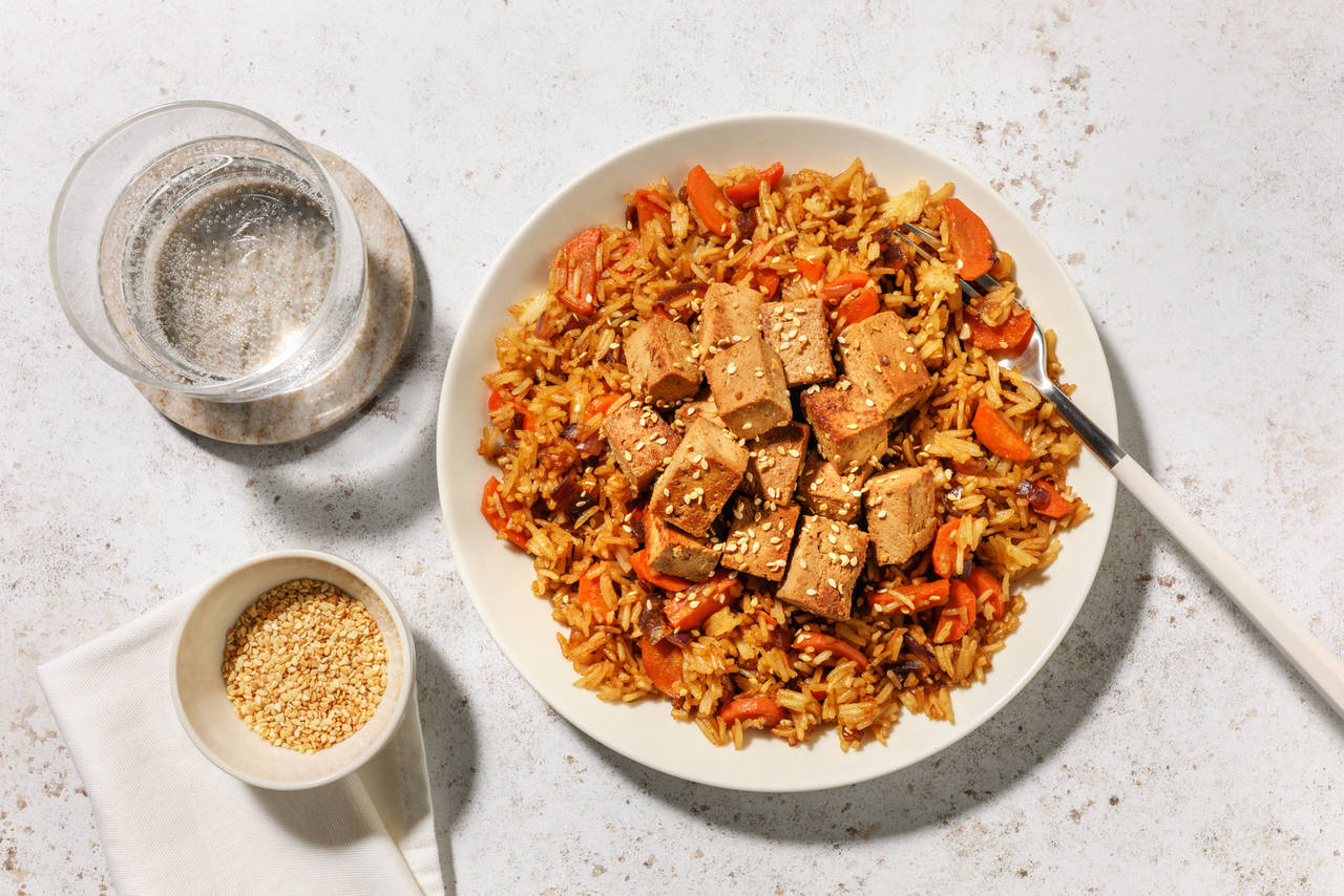 Dados de tofu marinados al estilo asiático con arroz frito con verduras y salsa teriyaki