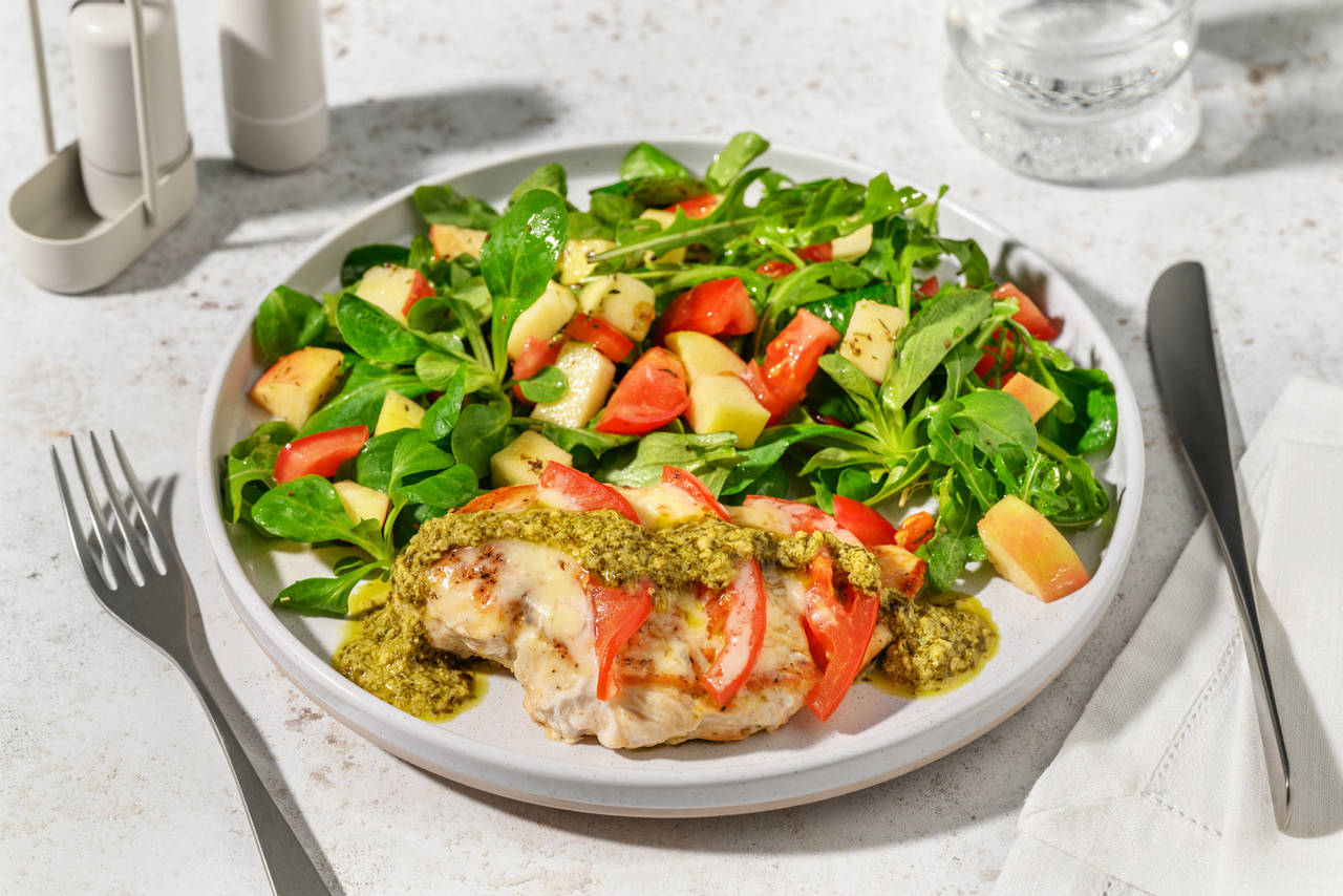 Pollo caprese con pesto de albahaca con tomate, queso italiano y ensalada de manzana