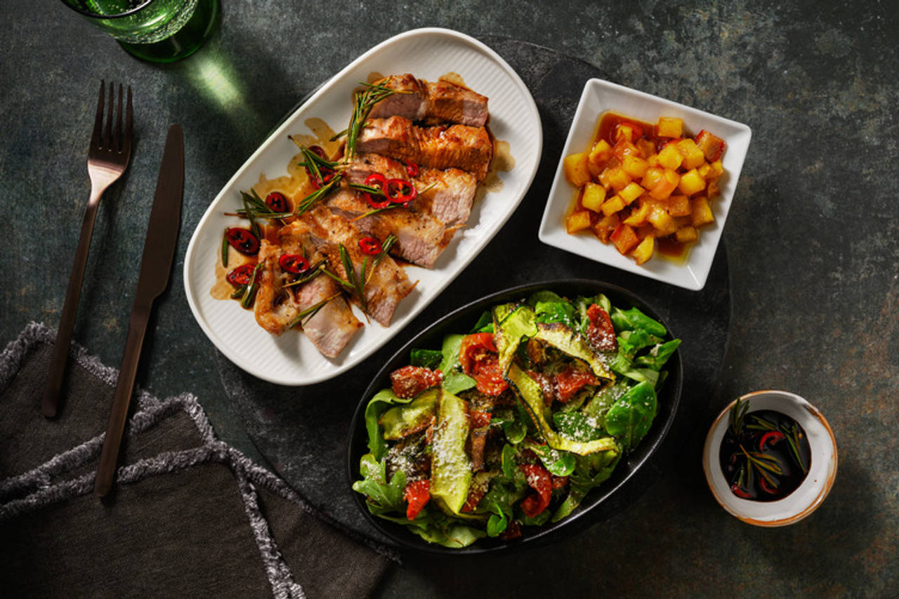 Secreto de cerdo al aceite de romero con manzana caramelizada y ensalada de calabacín y tomates secos