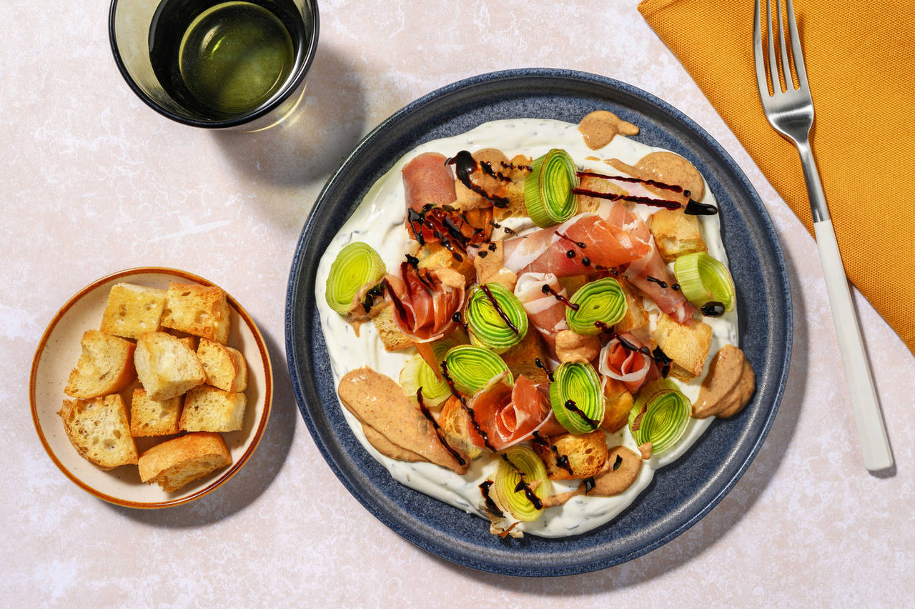 Puerros asados con jamón serrano y picatostes con yogur al tomillo y mantequilla de cacahuete