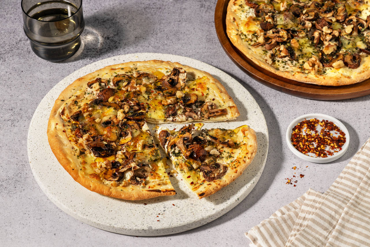 Pizza bianca con setas portobello y miel con nueces y mozzarella fundida